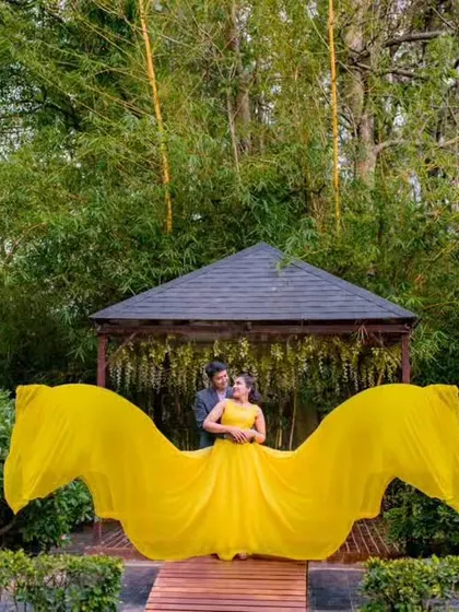 This shot shows the full "flying" effect of the yellow gown, with the fabric spread out like wings behind the couple.