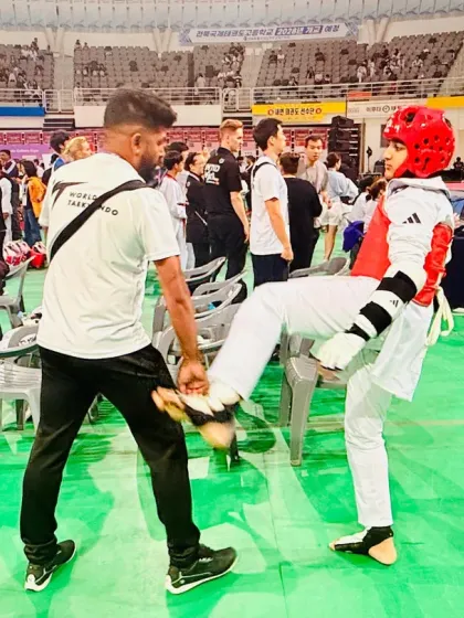 Pre-match warm-ups are crucial. Here, I'm helping my student with some light kicking drills to prepare for his international Kyorugi bout.
