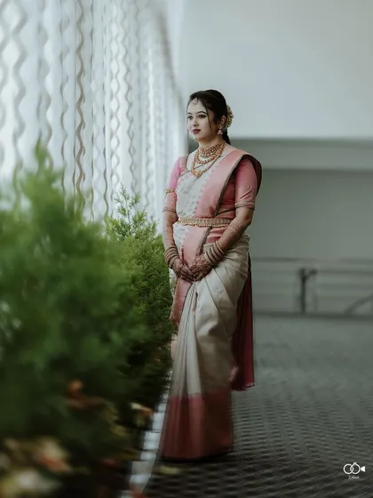 A full-length portrait of the bride looking elegant and poised by a window.