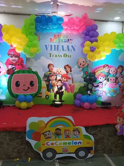 A full view of the Cocomelon stage, showing the colorful balloon arch and various character cutouts that bring the popular show to life.