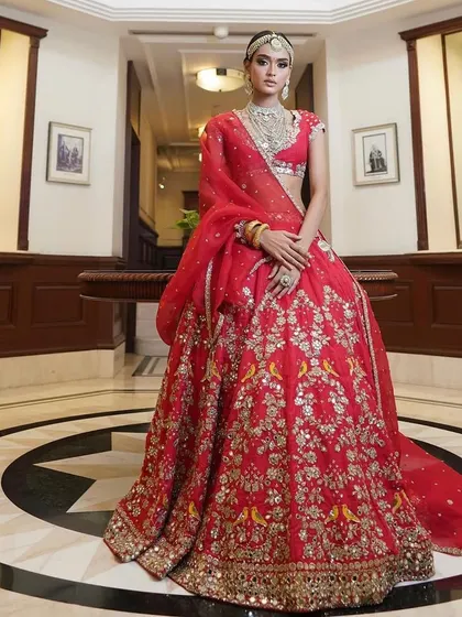 A full-length shot of a bride in a stunning red lehenga. My course covers posing and presentation to help you get the best portfolio shots.