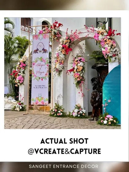 A beautiful sangeet entrance arch adorned with an abundance of pastel pink and peach flowers.