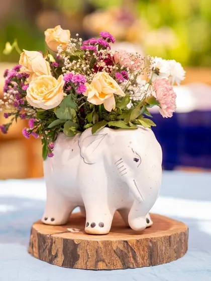 A cute elephant-shaped vase used as a centerpiece. These small, quirky details add personality and charm to the overall decor.