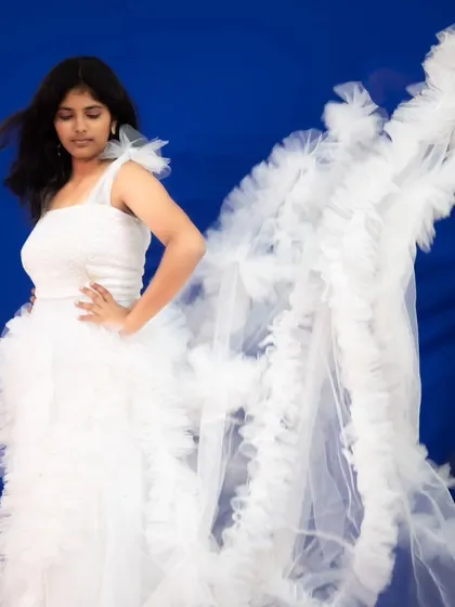 The detachable ruffle sleeves on this white gown create a stunning angel-wing effect.
