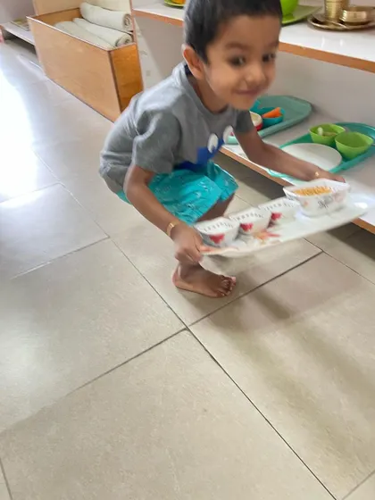 Carefully carrying a tray with materials requires balance, coordination, and focus. This practical life skill helps children develop body awareness and control, preparing them for more complex movements and tasks.