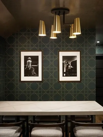 A sophisticated wine cellar featuring the 'Styled in Studs' collection from Phillip Jeffries. The refined geometric pattern adds a touch of modern charm and understated luxury, perfectly complementing the dark, moody ambiance.