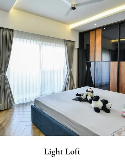 This 'Light Loft' bedroom reflects a modern minimalist style with clean lines, a built-in study desk, and a large glass-fronted wardrobe, creating a space of functional elegance.