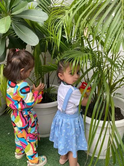 Two young gardeners carefully watering the plants. This simple activity is a great way to teach responsibility and the importance of caring for our planet.