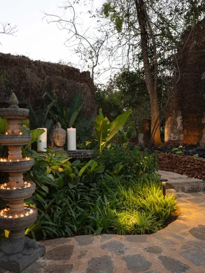A stone pathway at Sanctuary Bar, illuminated by candles and traditional lamps. The design guides visitors through a sensory journey, with fragrant plants and the soft glow of light enhancing the experience.