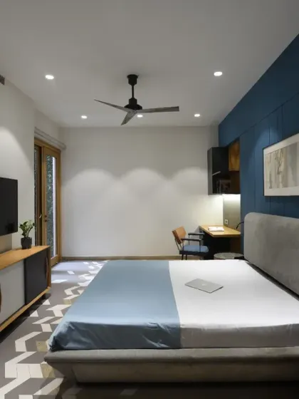This kids' bedroom in the Screen House features a crisp white canvas brought to life by a bold blue feature wall. Curated grey and blue furnishings add depth and texture, creating a harmonious and inviting atmosphere.
