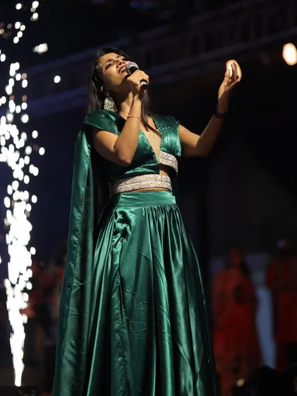 The sparklers in the background add to the magic of the moment. This green outfit was a perfect choice for the Deepavali Nights event.
