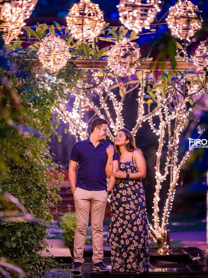 A sweet, candid moment under a tree wrapped in fairy lights. The lights create a magical, starry background for this romantic couple portrait.