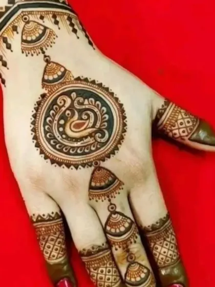 A chic and minimal back-hand design featuring a central swan motif with hanging jhumka elements. This is a great example of party mehndi that is both quick and beautiful.
