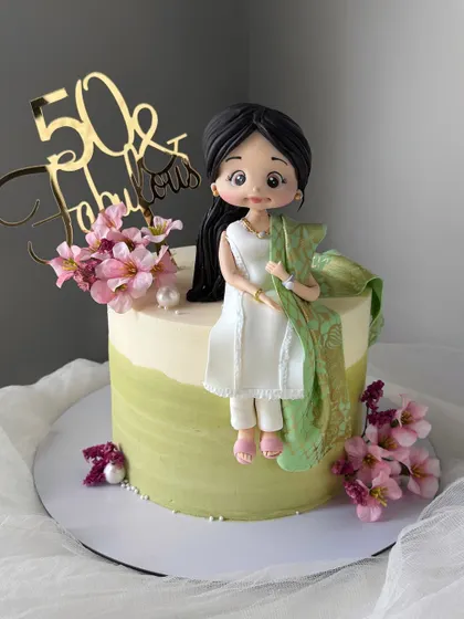 A closer look at the handcrafted figurine from our "gorgeous dupatta" cake. Every detail, from the dress to the flowers, is meticulously crafted to create a personalized masterpiece.