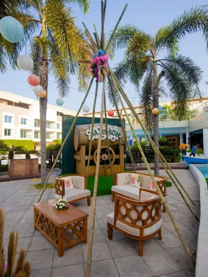 A cozy seating area with a teepee-style bamboo structure, perfect for a relaxed carnival or mehendi function.
