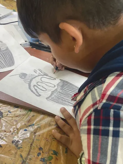 Even a simple cupcake can be a great subject for a sketching lesson. This young artist is learning about form, shading, and how to represent light on a curved surface.