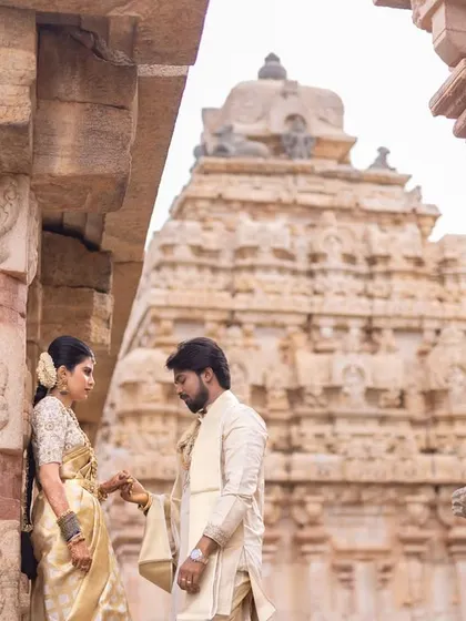 Using the temple's magnificent gopuram as the backdrop, this shot emphasizes the scale and cultural significance of the setting, making their love story feel epic.