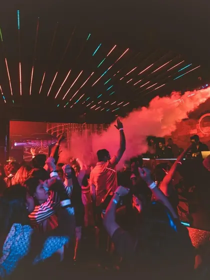 The club is filled with red smoke and a wild crowd. This shot captures the chaotic energy and immersive atmosphere of my sets.