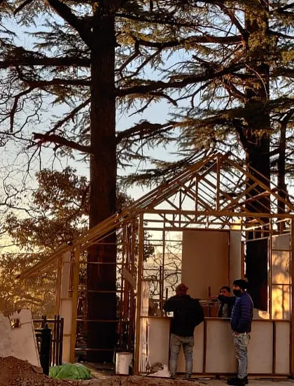 The cafe kiosk under construction amidst the deodar trees. This image captures the process of creating a new community nerve center, using local building techniques and materials to ensure the structure belongs to its environment.