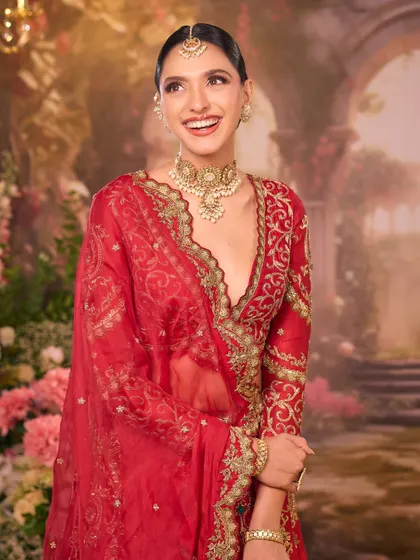 A candid moment of laughter. This image captures the bride's happiness, with her elegant red attire and our timeless makeup shining through.