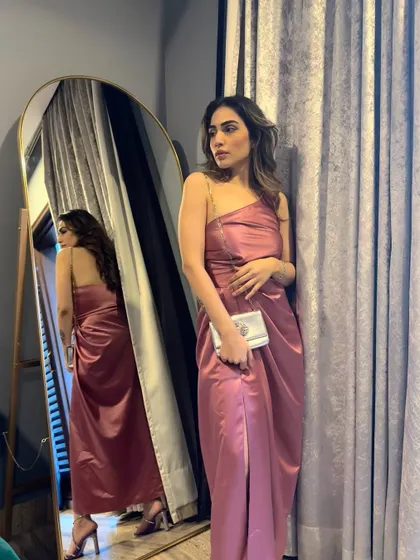 A mirror selfie in the pink dress, showing how the chain strap detail adds a modern touch.