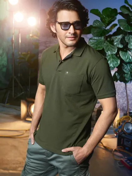 A campaign shot for Otto Clothing with Mahesh Babu on a set. The use of studio lights as part of the background gives the image a cool, behind-the-scenes feel while maintaining a polished look.