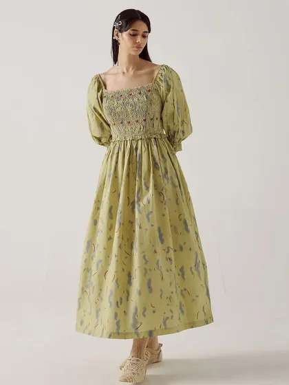 A full-length shot of the Smocked Dress from Cord, showcasing its elegant silhouette against a clean studio background.