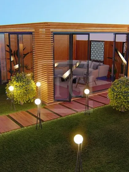 A view of the glass house in the Gurgaon project, designed as a cozy, transparent room within the garden.