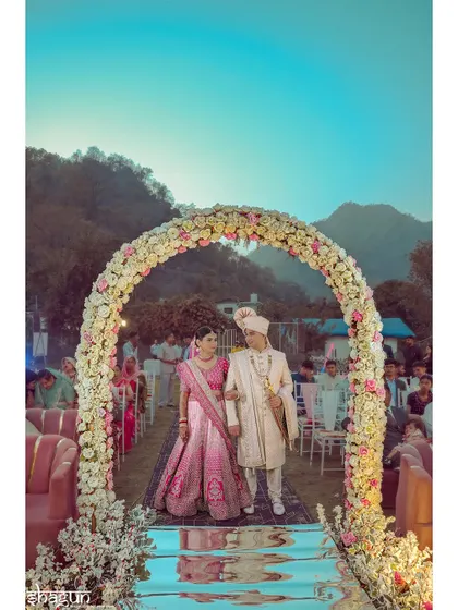 Walking into their forever under a stunning floral arch, with the mountains witnessing their union. A perfect destination wedding shot.
