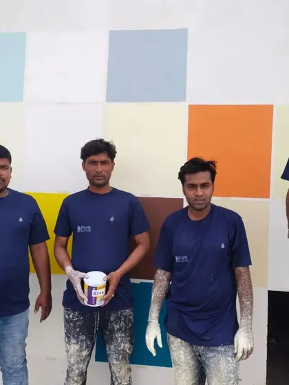 Our painters showcasing a can of high-quality paint, reflecting our commitment to using the best materials for a durable and beautiful finish.