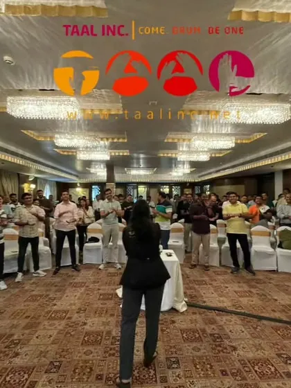 Even without a perfect circle, the energy is palpable. Our facilitator Neha leads a corporate group in an interactive drumming session, proving that rhythm can connect people in any setting.