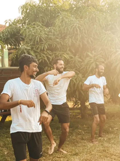 Spontaneous moments of dance and joy in the sunlit garden. Life here is about more than just asanas; it's about celebrating life and expressing our energy freely.