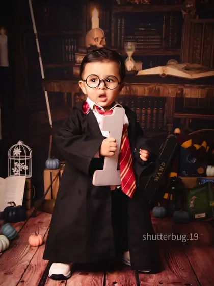 Expecto Patronum! This little wizard is ready to cast a spell, dressed in his Hogwarts robe for a magical Harry Potter shoot.