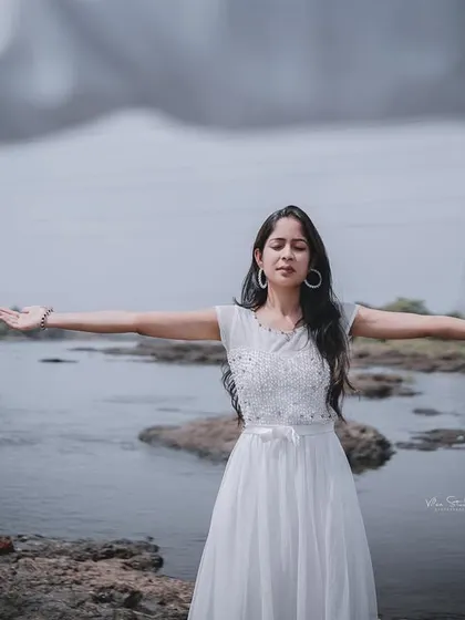 A close-up of the bride-to-be in a free-spirited pose. The focus is entirely on her serene expression and the beautiful natural setting.