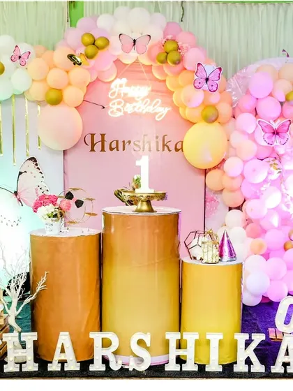 A beautiful butterfly-themed setup for a first birthday. The pastel pink and yellow balloon arch is accented with gold balloons and delicate butterfly cutouts for a soft, dreamy look.