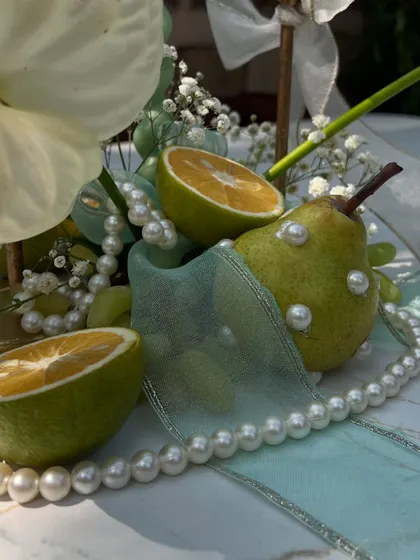 A detailed shot of a table centerpiece, where we incorporated fresh fruit and delicate pearls for a touch of unique elegance.