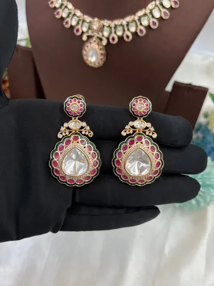 The earrings and maang tikka from our Amaya Premium Moissanite Kundan set. Notice the delicate Meenakari border and the large central stone.