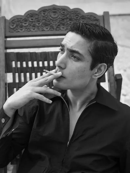 A thoughtful and composed portrait in a classic wooden chair. The black and white treatment adds a timeless, sophisticated quality.