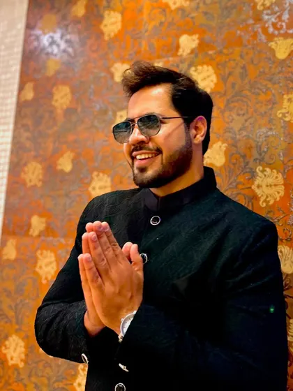 A respectful Namaste pose in a formal bandhgala, blending tradition with modern style.