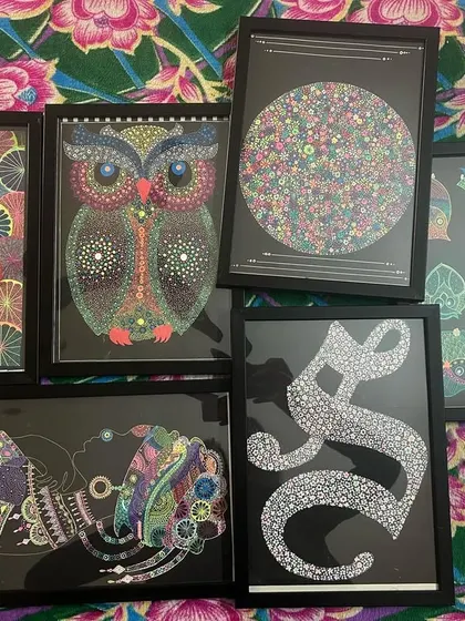 A collection of my framed artworks, including an owl, African art, and initial art.