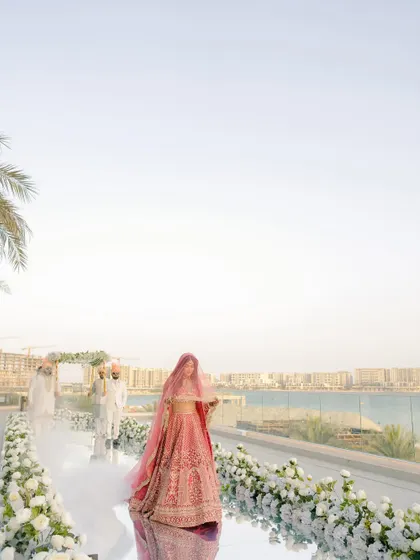 The bride's walk to the mandap, with the Abu Dhabi skyline in the distance. A breathtaking shot that combines tradition with a modern, international setting.