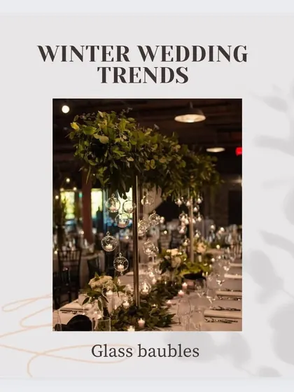 A winter wedding trend alert featuring glass baubles with candles hanging from a tall floral centerpiece, creating a magical and festive look.