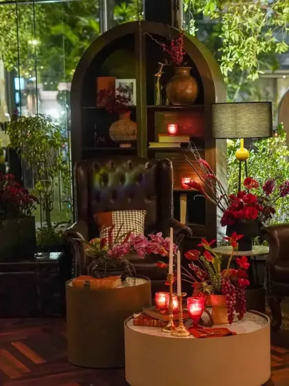 Every corner tells a story. This vignette features classic leather armchairs, a curated bookshelf, and moody floral arrangements, creating a perfect photo opportunity and a quiet space for guests to relax.