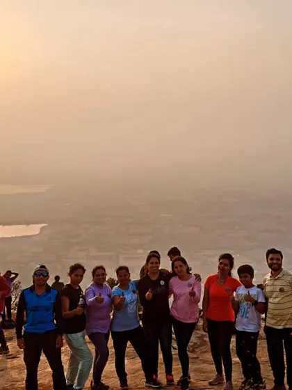 A family and other trekkers posing together at the Skandgiri sunrise point.