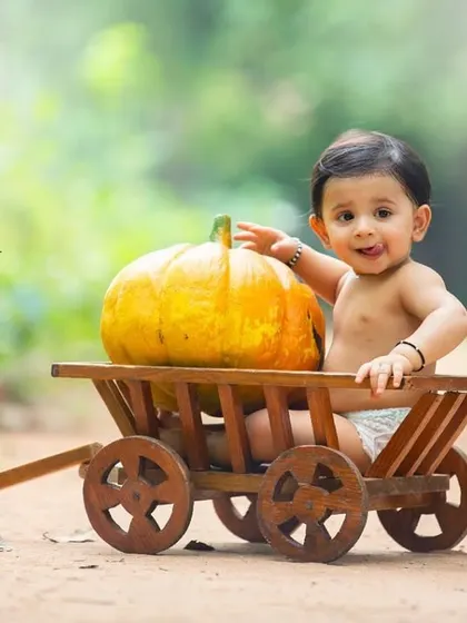 This joyful portrait captures a playful moment during a harvest-themed sitter session. The simple setup keeps all the attention on his adorable face.