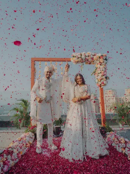 The couple raises their hands in celebration after their Varmala, a moment of pure joy.