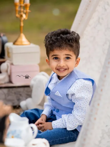 Capturing their innocence is our blessing. A simple, clean setup with a teepee allows this little boy's sweet smile to be the main focus.