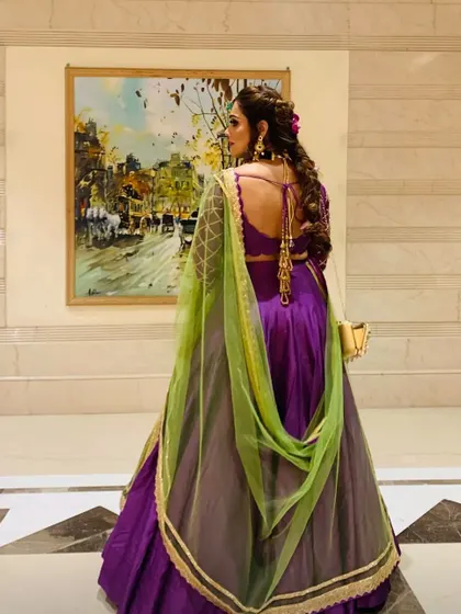 A look at the back of this bridesmaid outfit. The deep back and intricate tassels add a touch of modern glamour, while the braided hairstyle keeps it elegant and manageable for a long event.