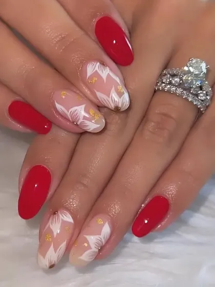 A bold and romantic set. Classic red nails are paired with accent nails featuring hand-painted white flowers and gold leaf flecks.