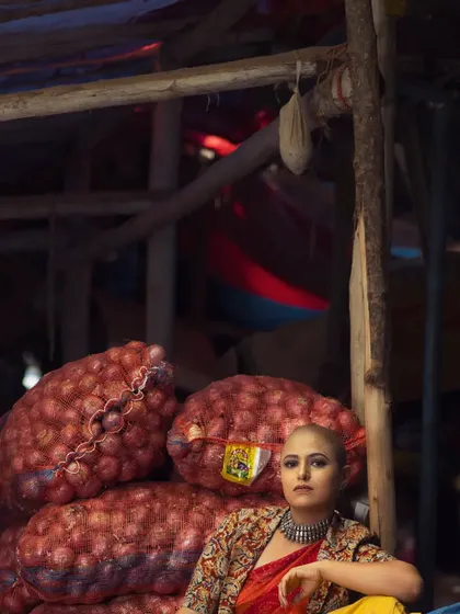 This editorial image places a bold, ethnic-inspired look in an everyday market setting. It's a celebration of finding beauty and power in unexpected places.